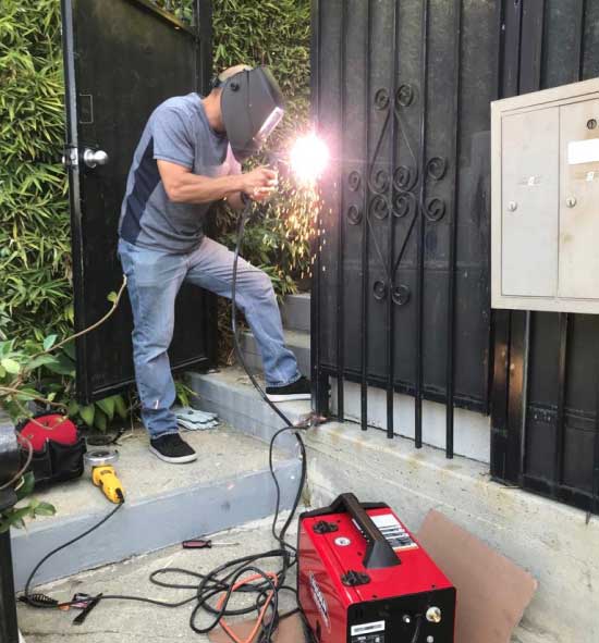man using torch to repair a gate